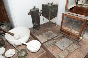 Muzei180_Аналитична везна, ръчна преса, машина за пилюли, преси за капсули, сушилня, инфузионен апарат и хавани с пестик от първата пол